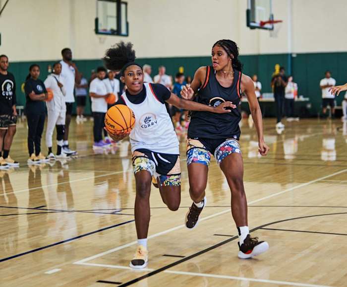 Two female basketball players compete at Stephen Curry's camp.